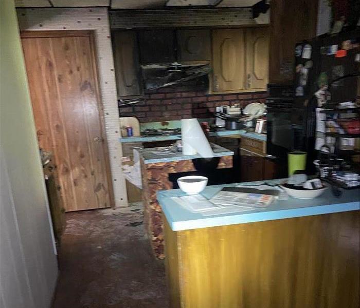 The before image shows the damage done to a kitchen after a house fire.